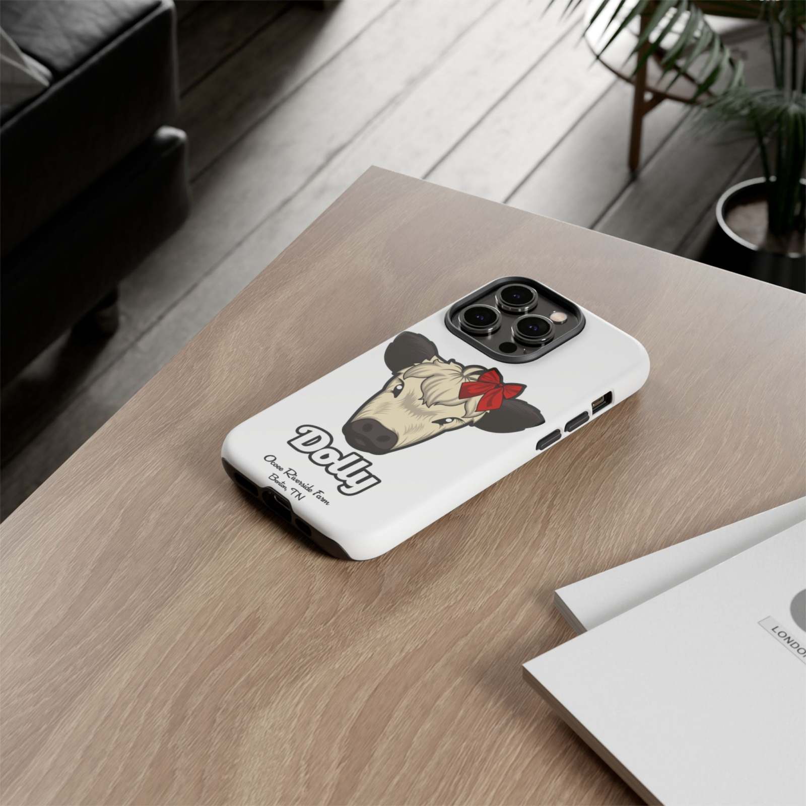 Farmhouse Chic Phone Case with Dolly the Cow design on wooden table.