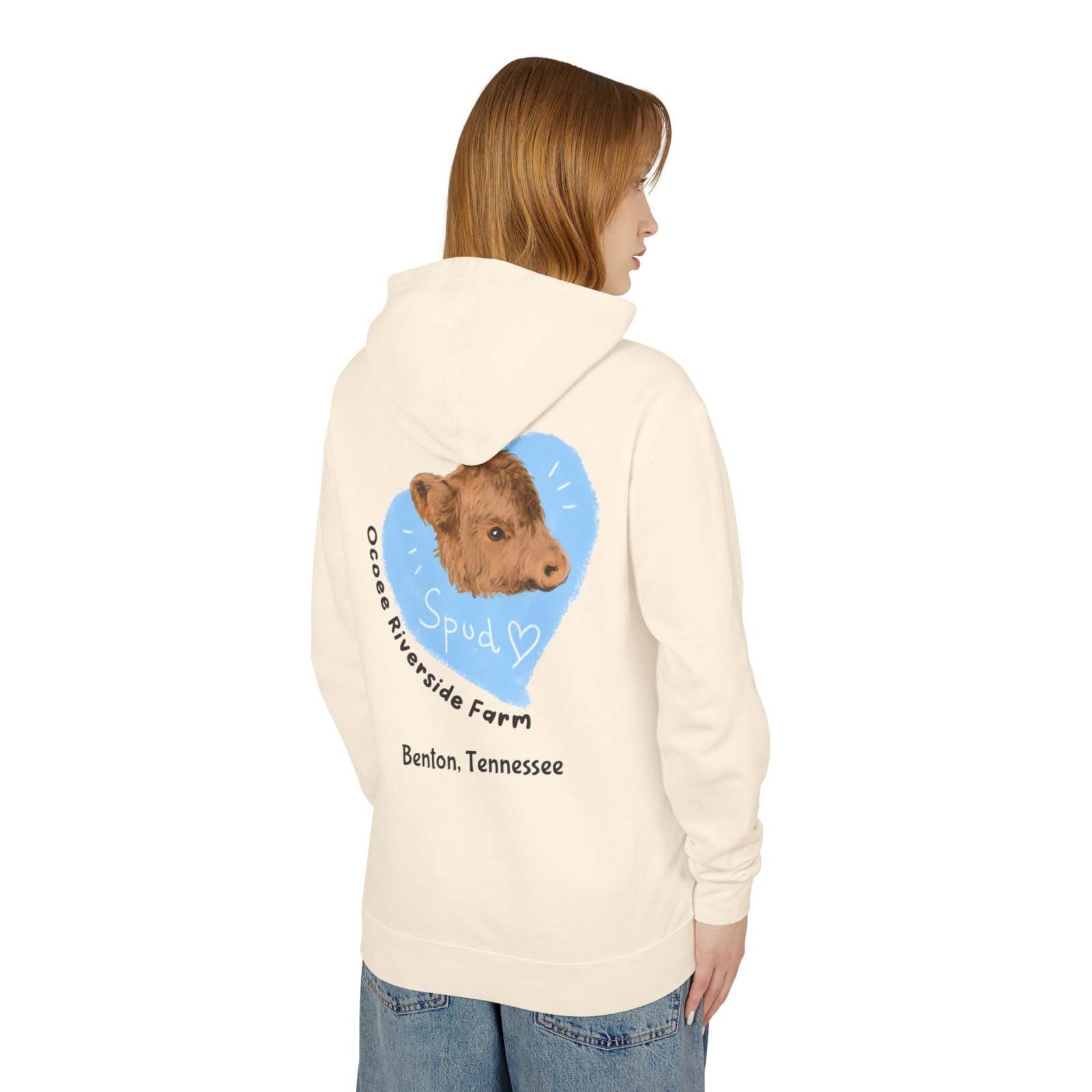 Woman wearing a cozy Cute Cow Lightweight Hoodie with a calf graphic and farm name on the back, in a soft cream color