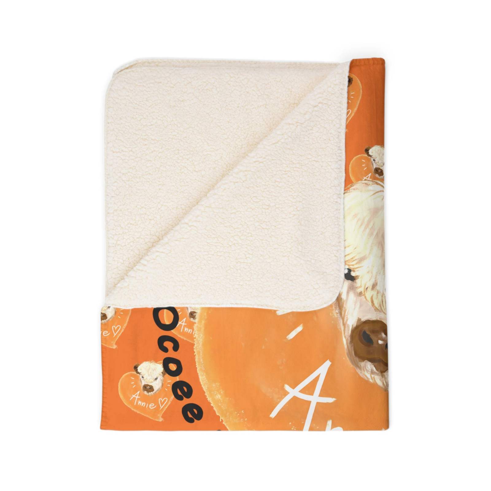 Folded cow-themed Sherpa blanket with soft cream Sherpa on one side and orange cow print on the other.