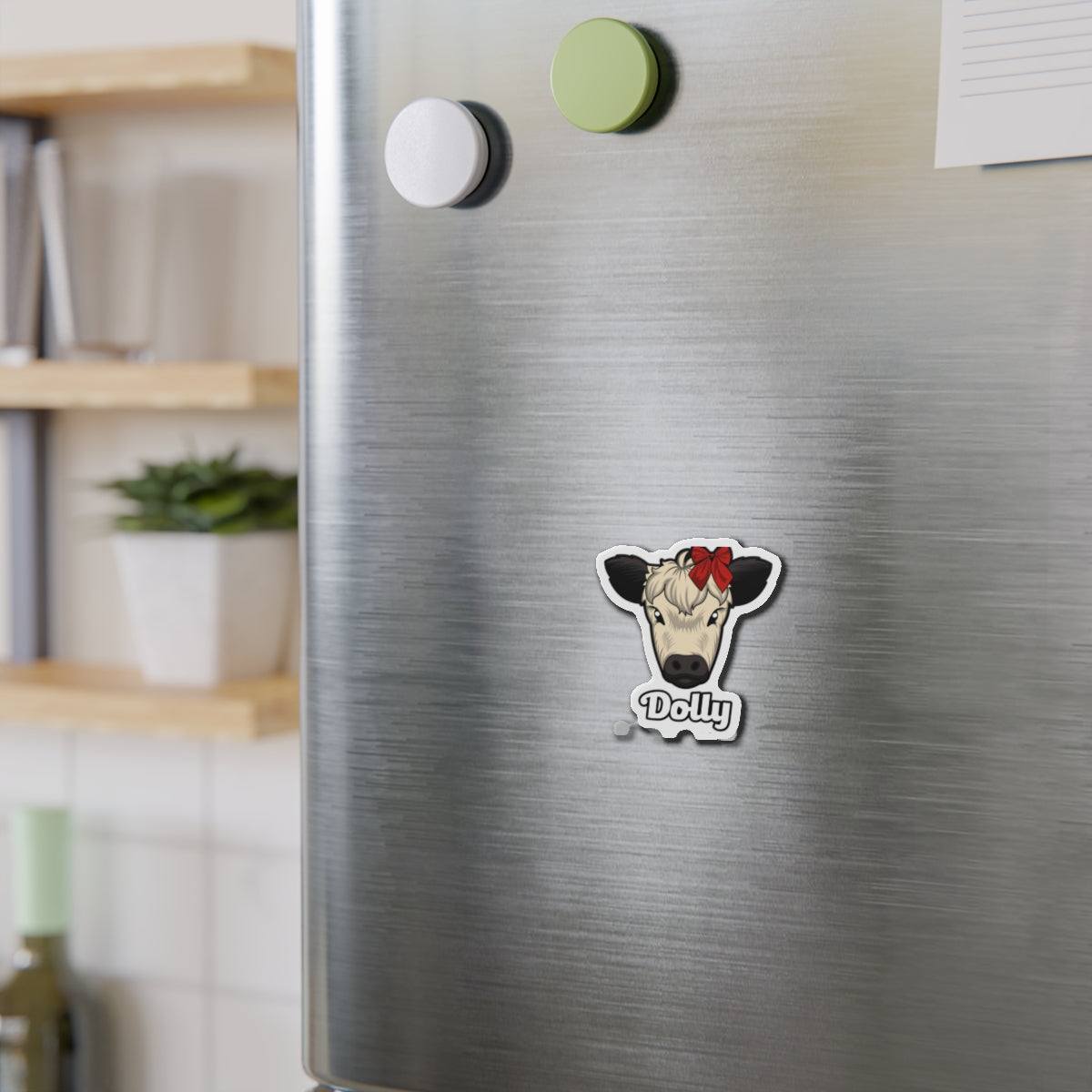Charming Cow Die-Cut Magnet with cow face and red bow on stainless steel refrigerator door.