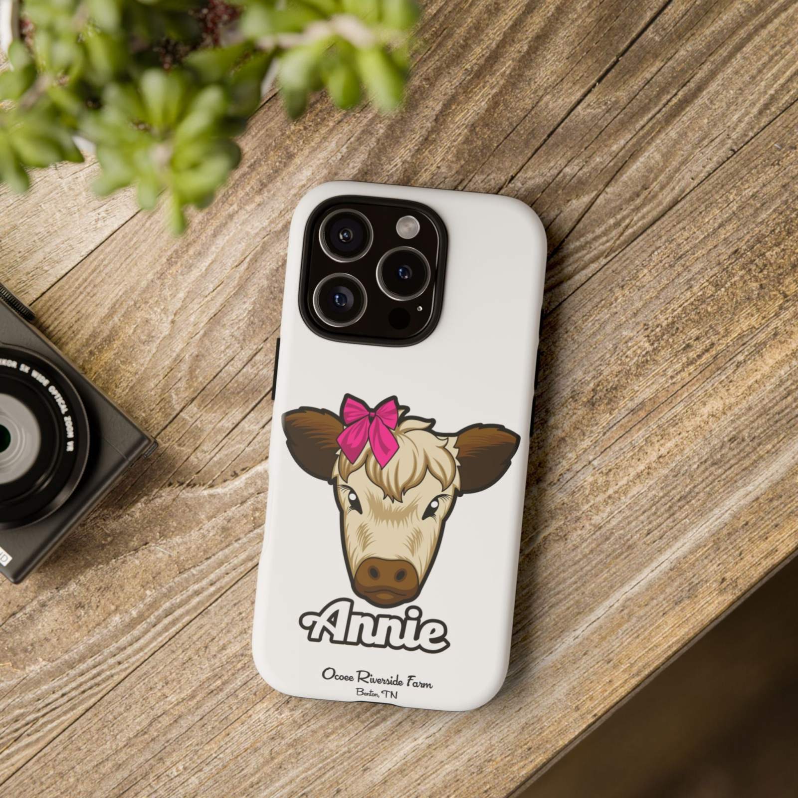 Cute Annie the Cow phone case with red bow on wood surface; ideal farm animal lover gift.