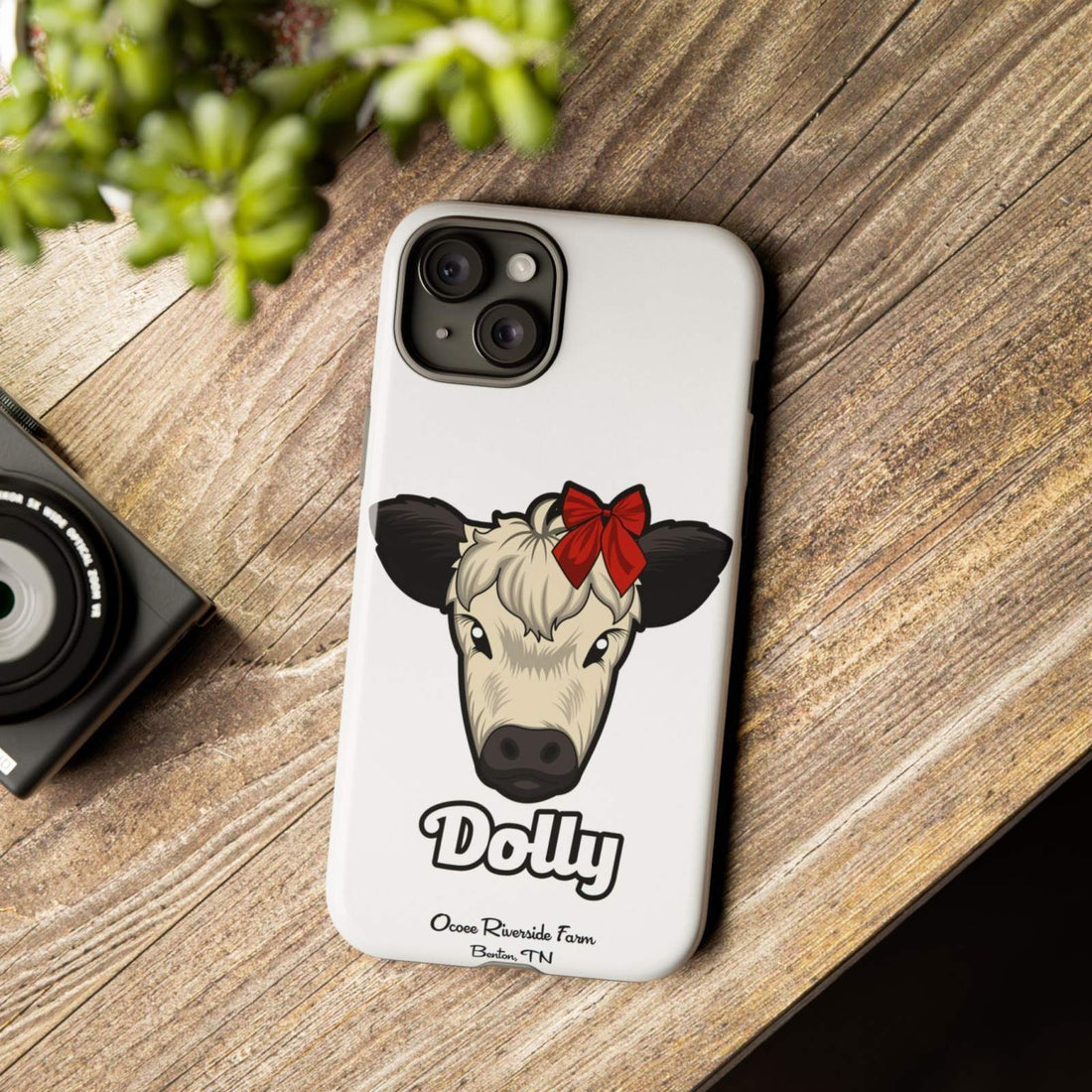 Farmhouse Chic Phone Case featuring a cow with a red bow on a wooden table.