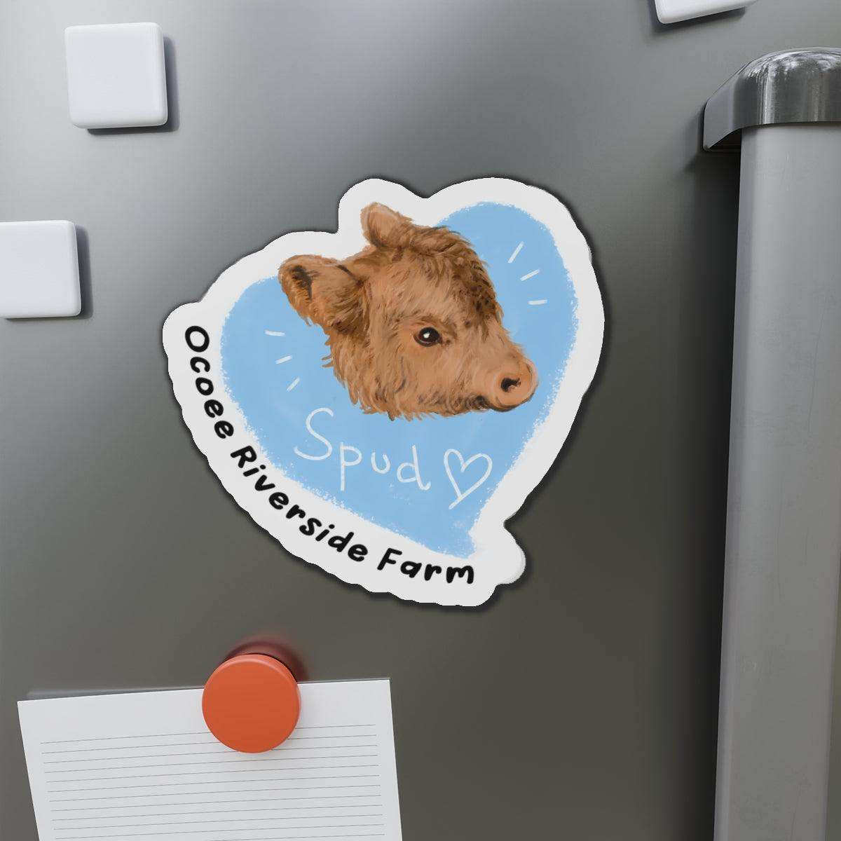 Farm Animal Decor Magnet featuring a cute cow head illustration on a blue heart background with "Ocoee Riverside Farm" text, adhered to a gray metal surface.
