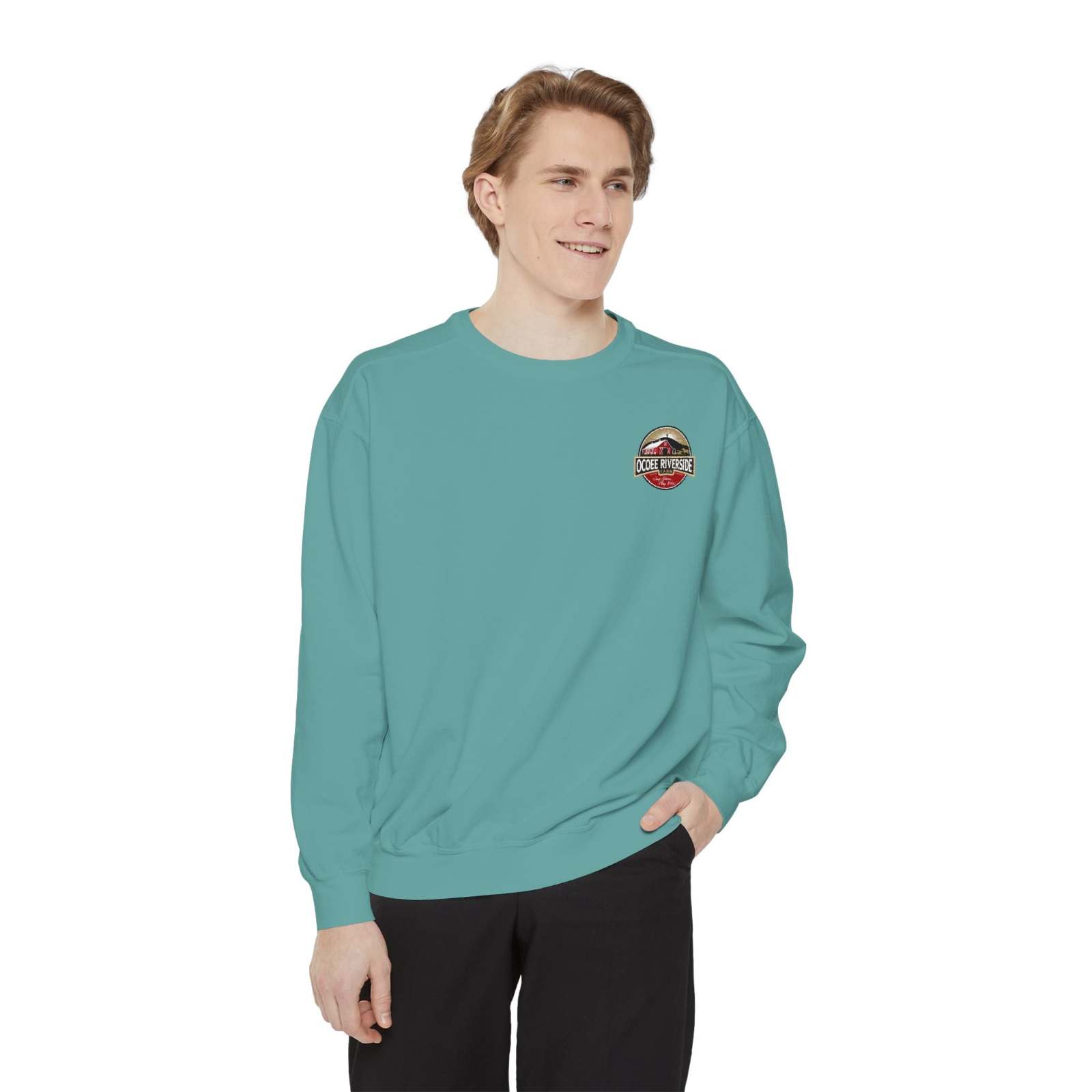 Man wearing a teal Farmhouse Cow Sweatshirt with a cow print and red bow embroidery.