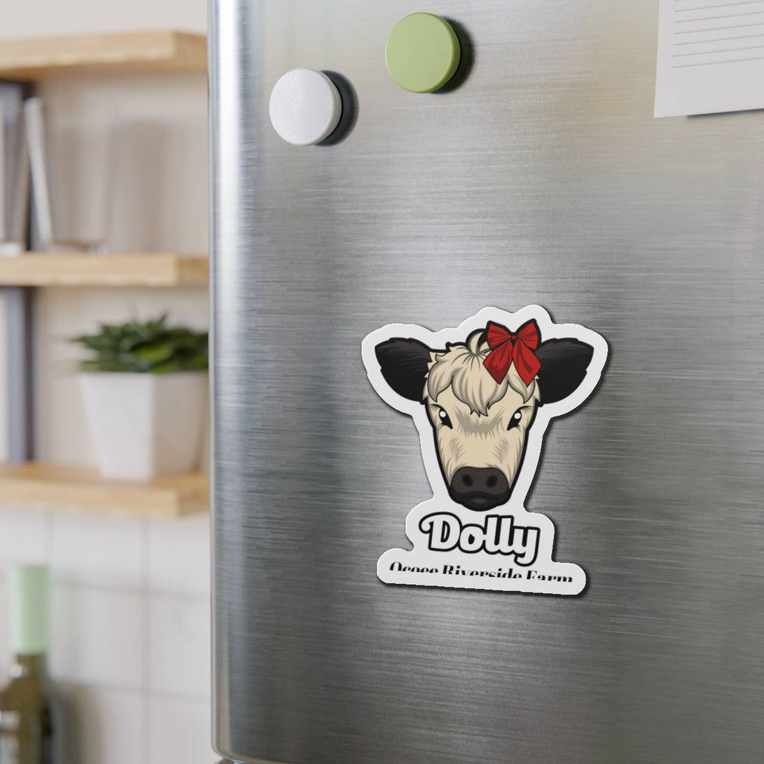 Charming Cow Die-Cut Magnet with cute cow face and red bow on stainless steel refrigerator.