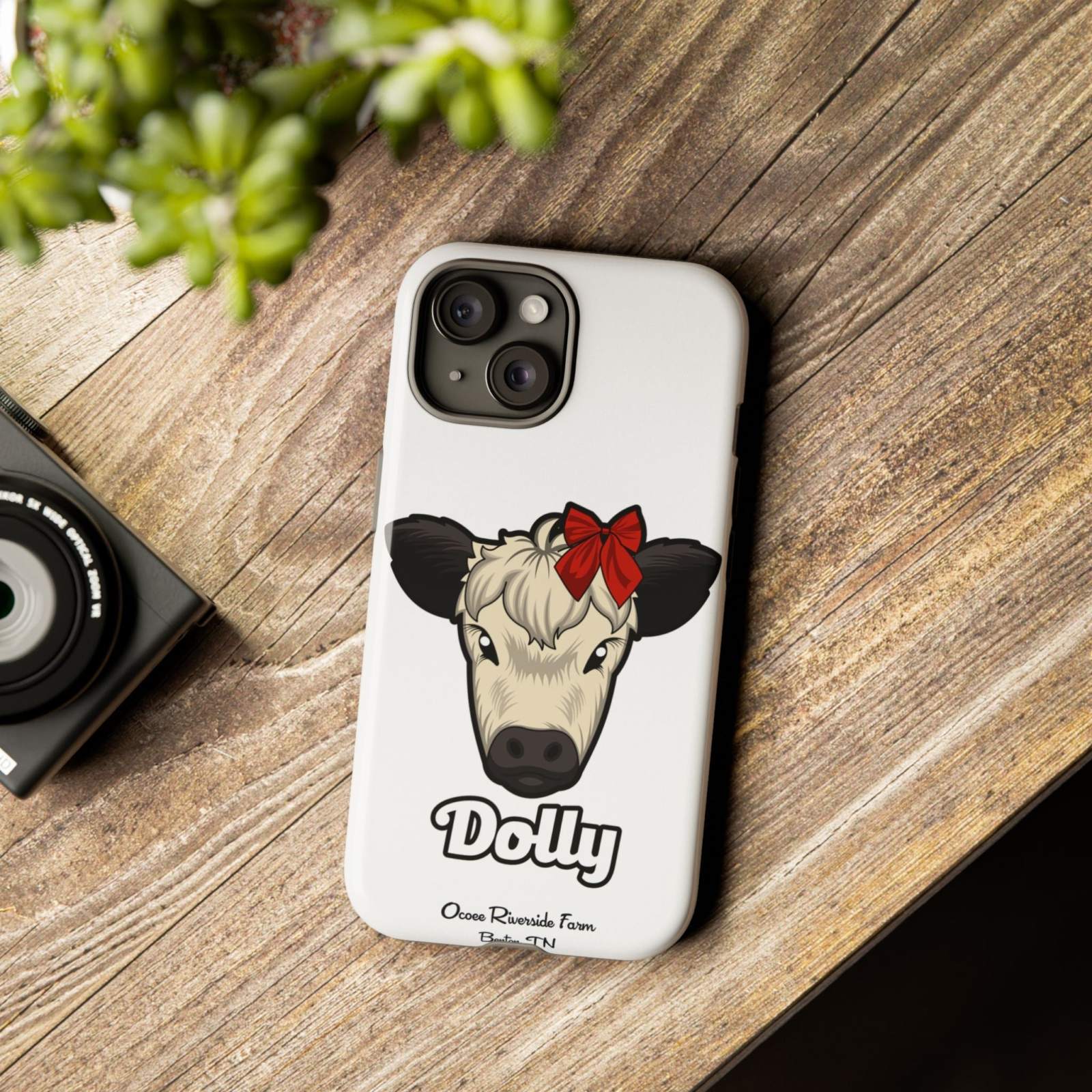 Farmhouse Chic Phone Case with Dolly the Cow design on wooden table.