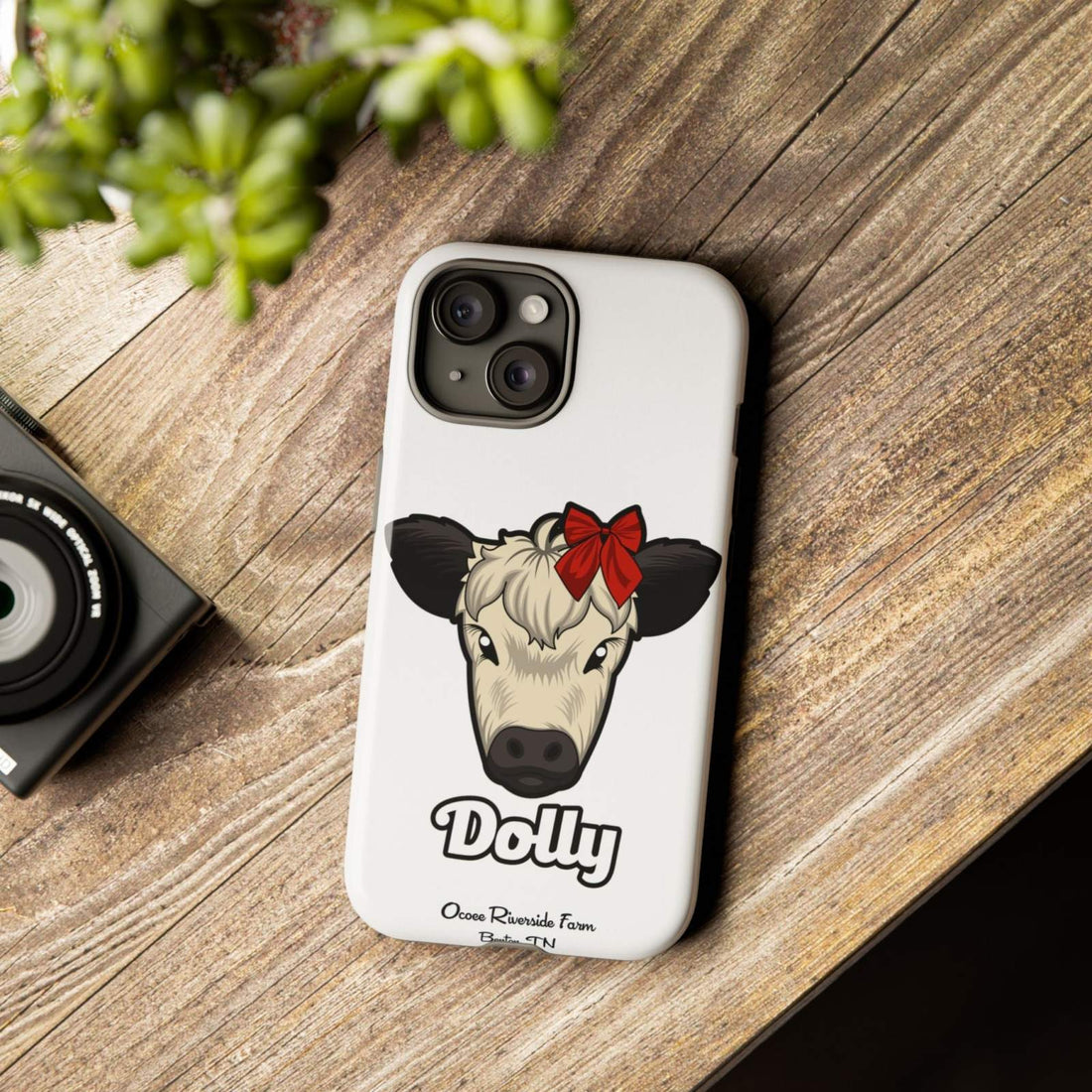 Farmhouse Chic Phone Case with Dolly the Cow design on wooden table.