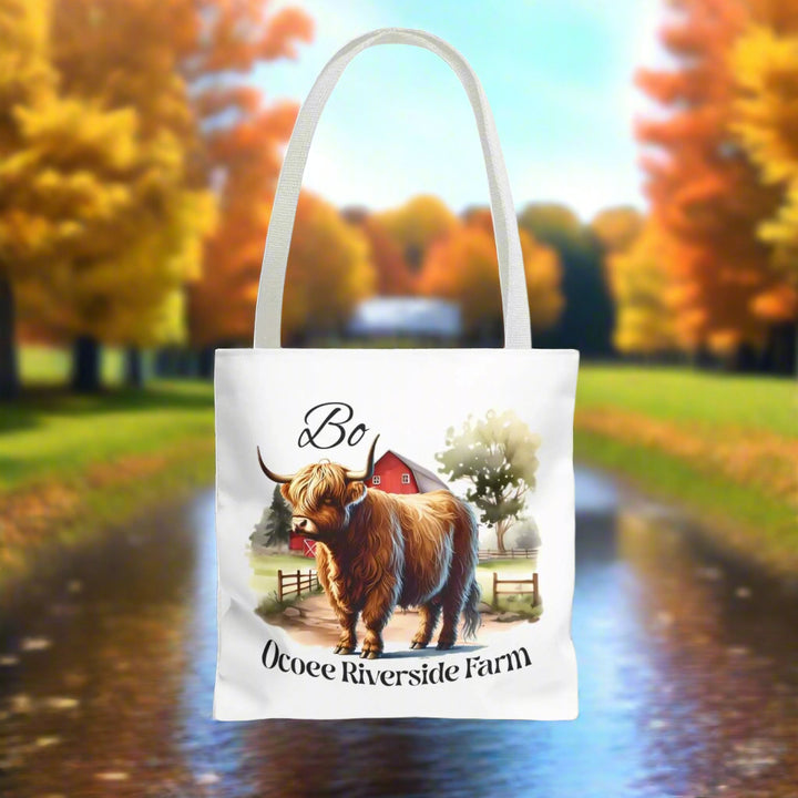 Eco-friendly Bo Scottish Highland Tote Bag with farm animal design and Ocoee Riverside Farm text, white background, durable polyester with reinforced handles.