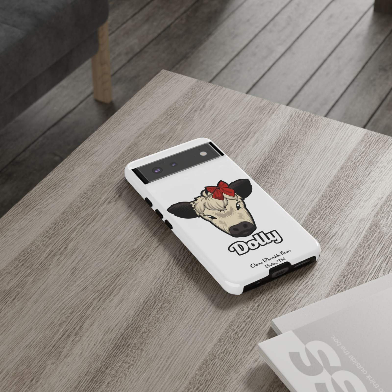 Farmhouse Chic Phone Case with Dolly the Cow design on a table.