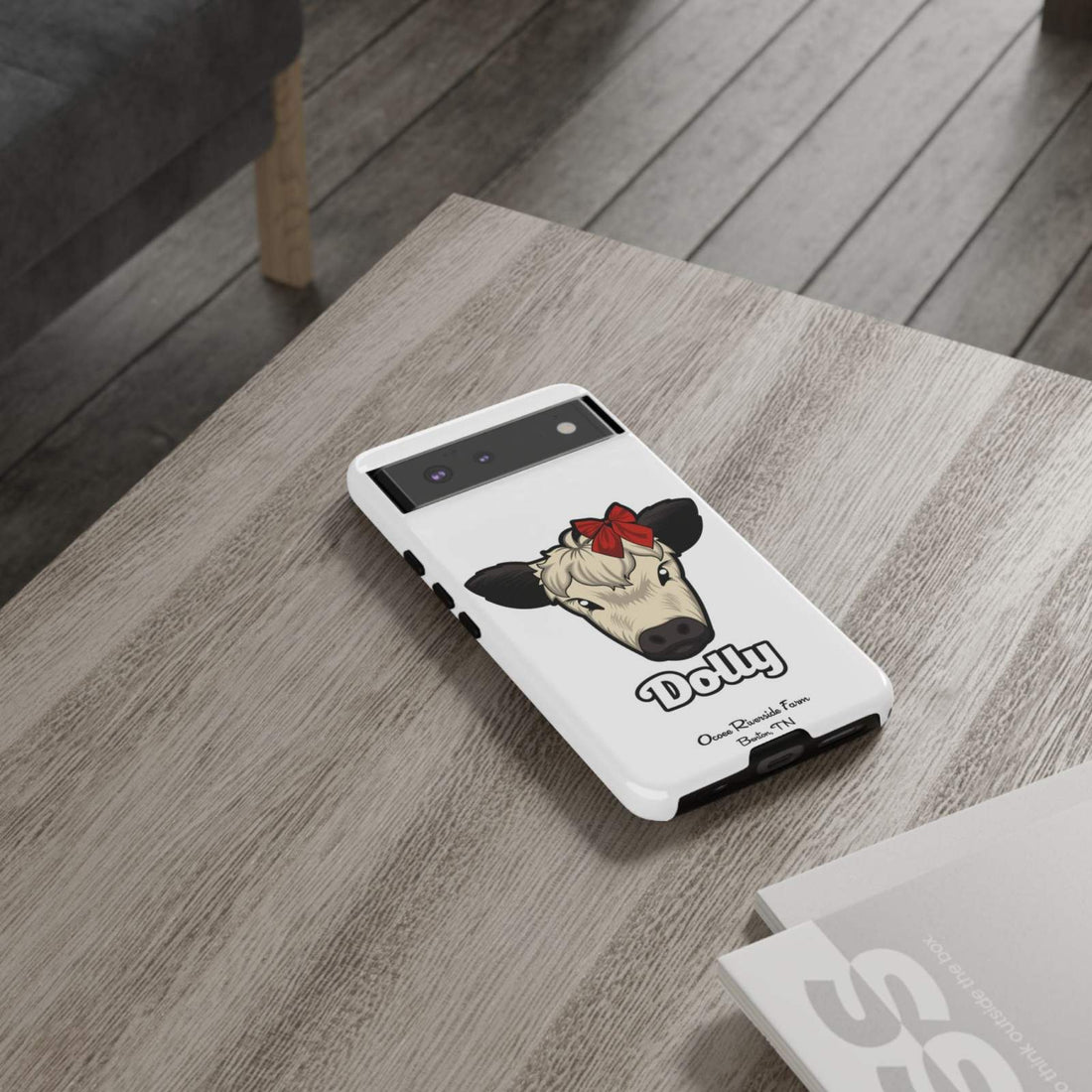 Farmhouse Chic Phone Case with Dolly the Cow design on a table.