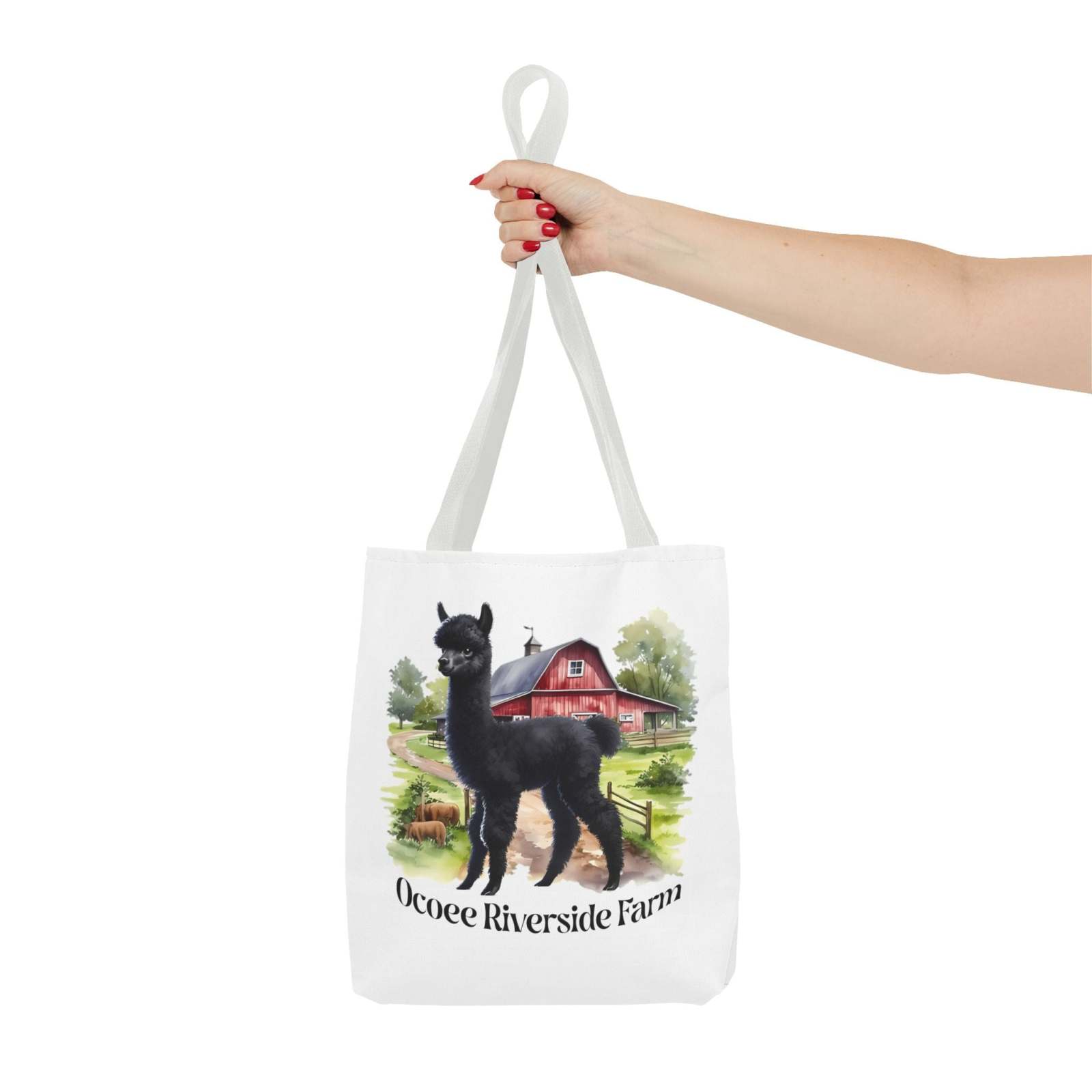 White eco-friendly tote bag featuring a black llama and Ocoee Riverside Farm illustration, held by a hand.