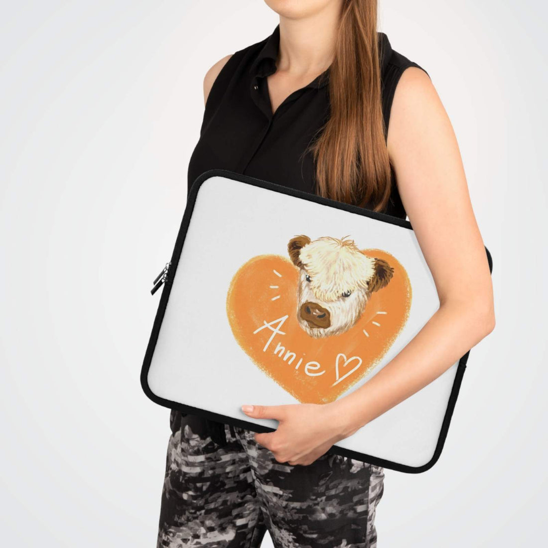 Custom Cow Laptop Sleeve with heart design and personalized name Annie held by woman