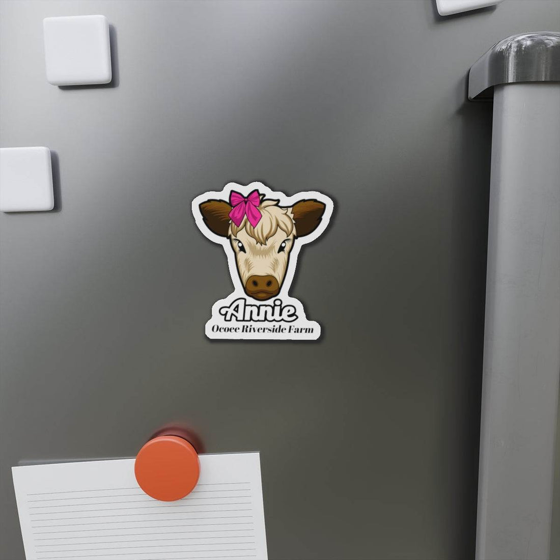 Cow Die-Cut Magnet with cute cow face and pink bow on gray fridge door, farmhouse decor accessory