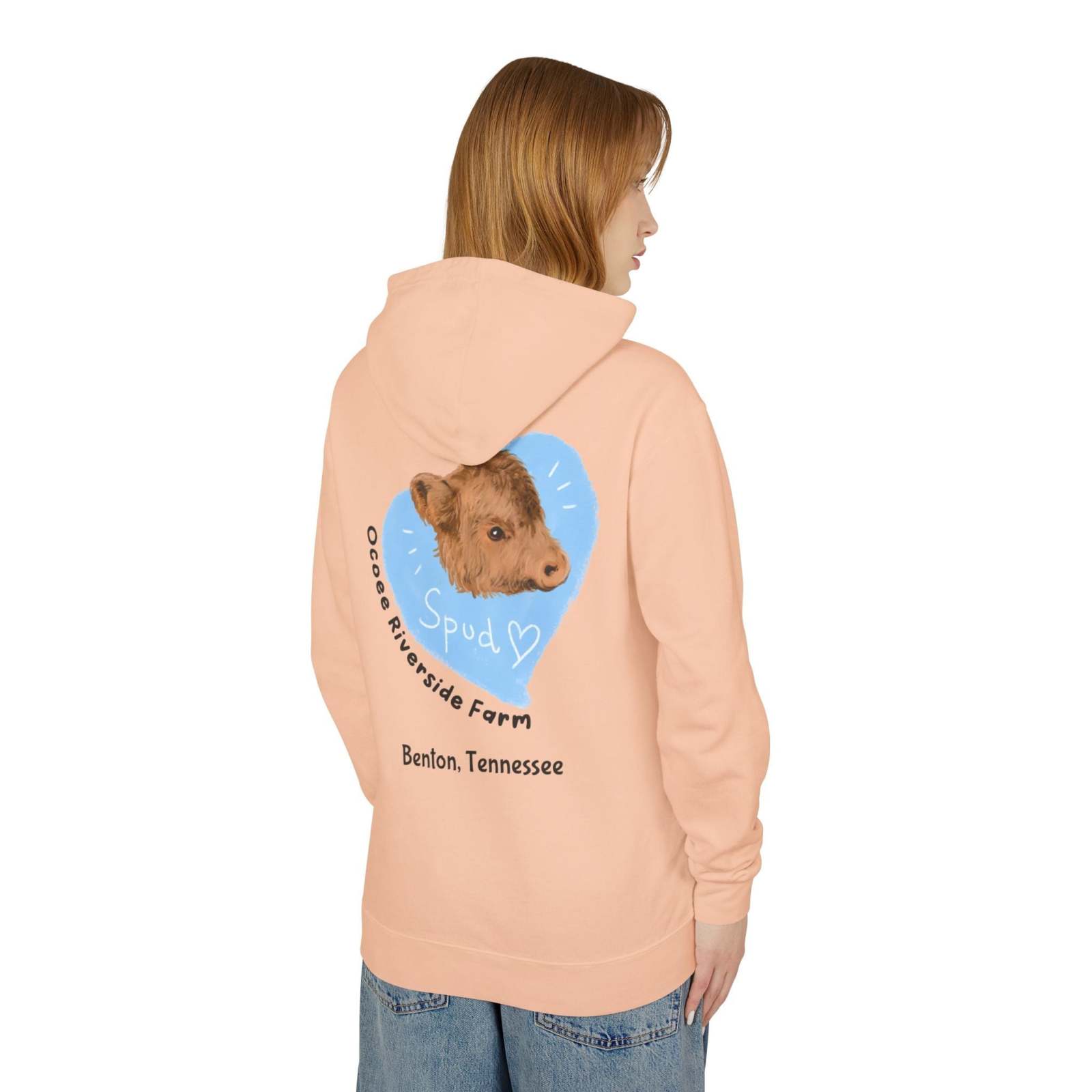 Woman wearing a peach Cute Cow Lightweight Hoodie with a calf graphic and "Ocoee Riverside Farm" text on the back