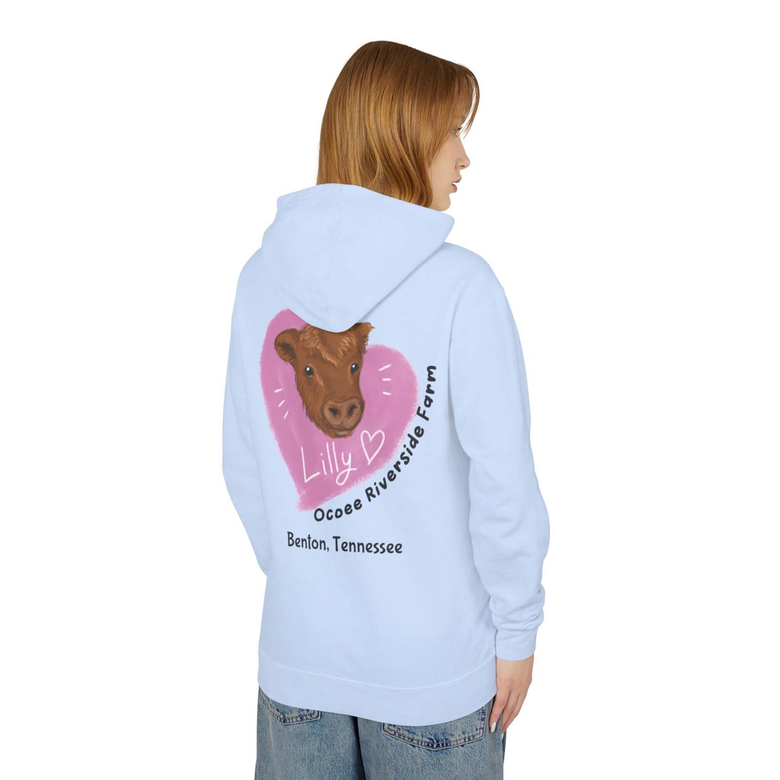 Light blue Cute Cow Hoodie with farm-themed cow graphic and heart design on back, worn by a woman, unisex lightweight sweatshirt from Ocoee Riverside Farm.
