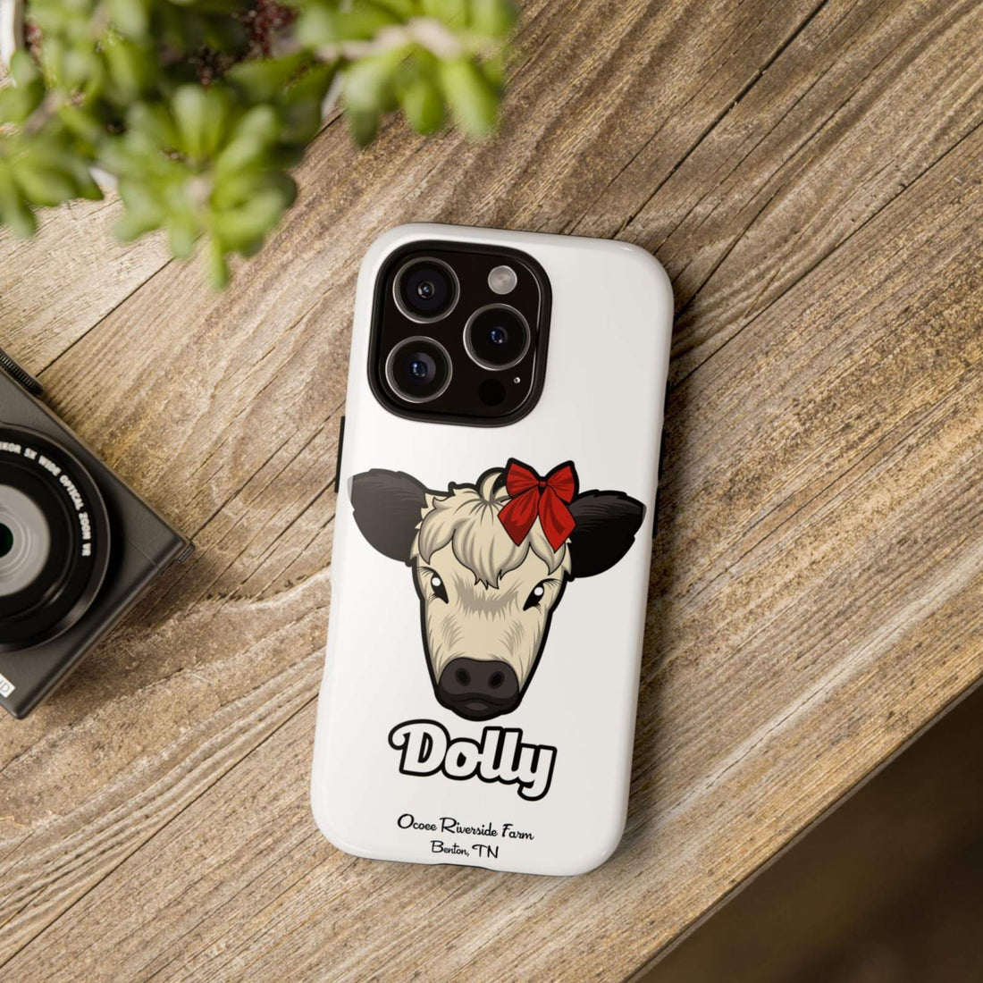Farmhouse Chic Phone Case with Dolly the Cow design and red bow on a rustic backdrop.