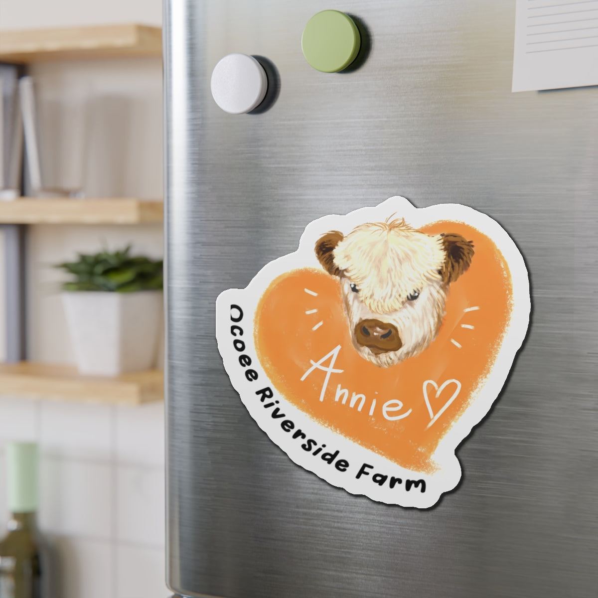 Cute cow design die-cut magnet with Annie text and heart on refrigerator door.