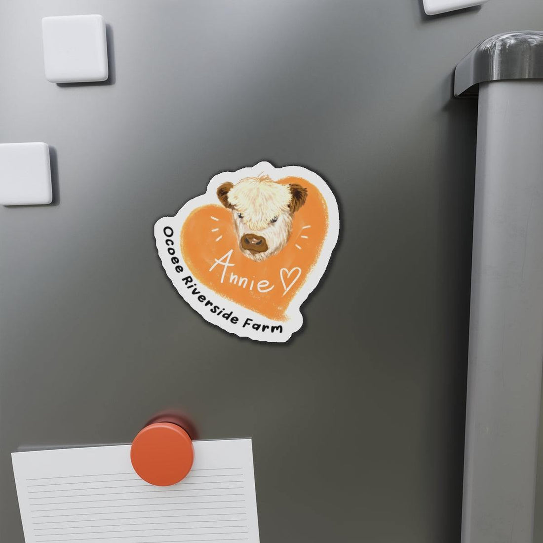 Cute Cow Design die-cut magnet with cow illustration and "Annie" text on a fridge.