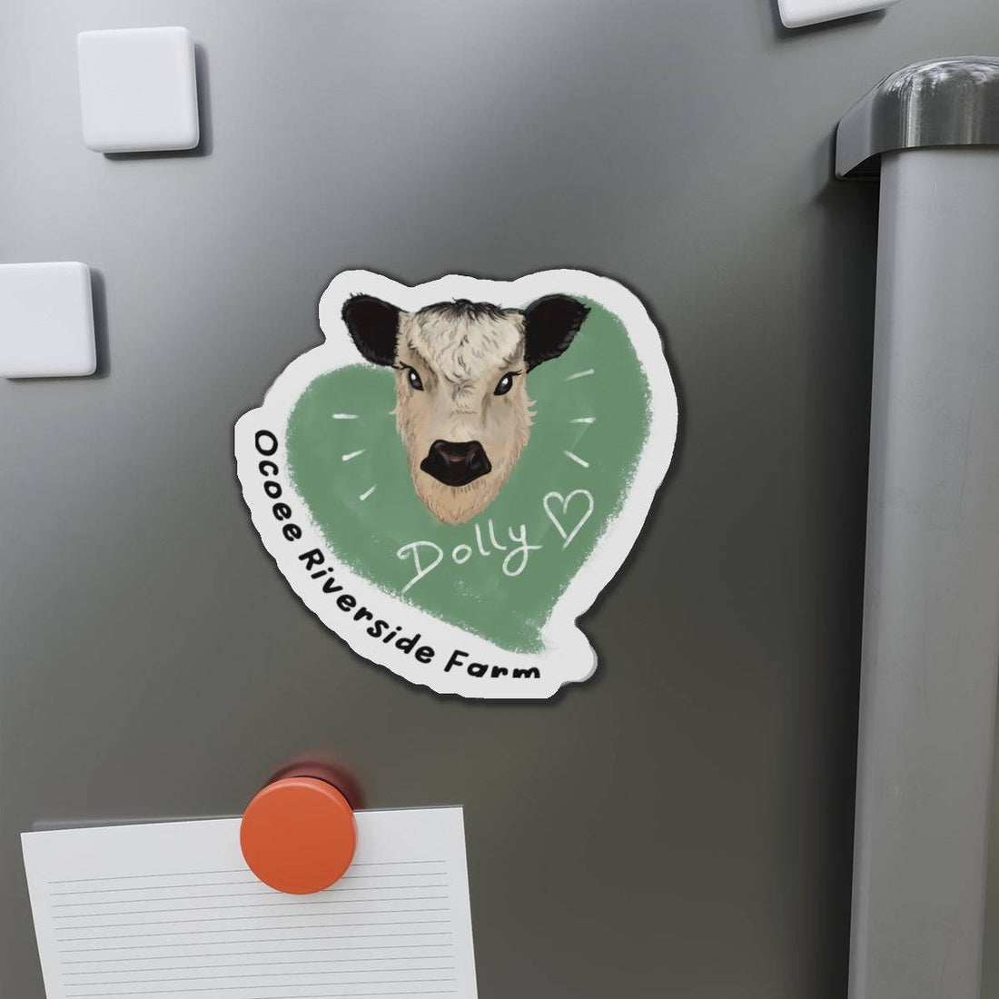 Cute Cow Die-Cut Magnet with cow face and green heart background on a refrigerator door