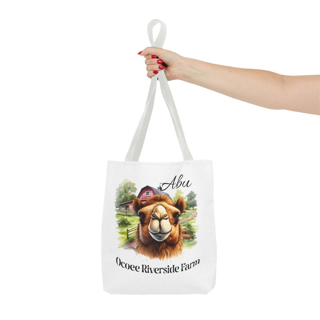 White Abu Camel Tote Bag featuring a camel illustration and Ocoee Riverside Farm text, eco-friendly shopping bag held by a hand