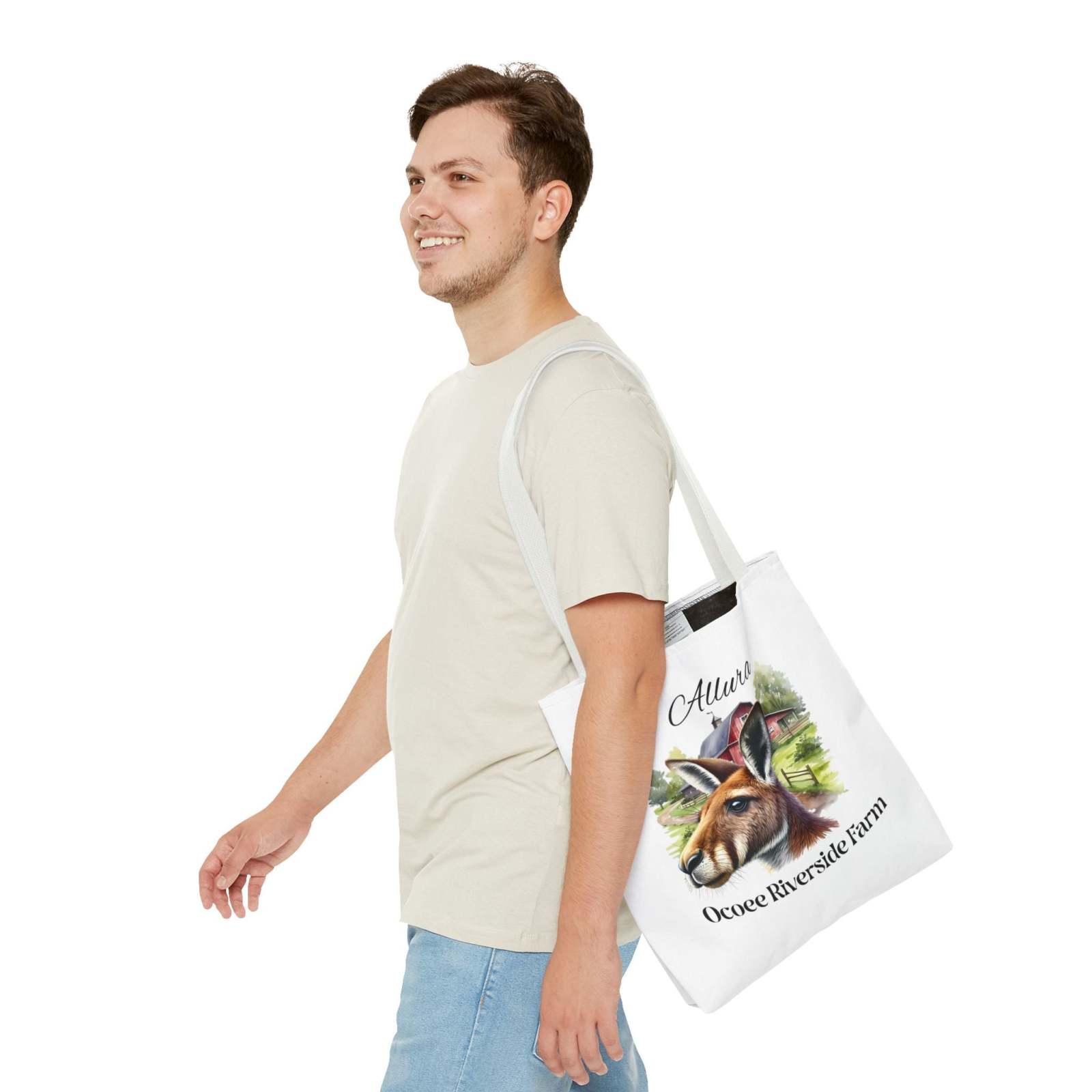 Man wearing beige t-shirt carrying white Allura Kangaroo Tote Bag with kangaroo illustration and Ocoee Riverside Farm text on shoulder