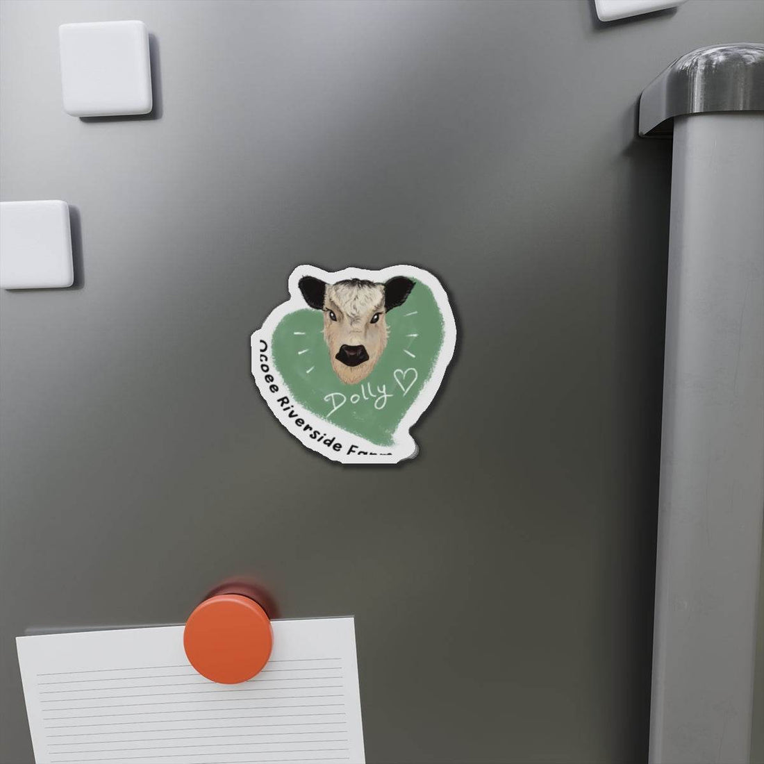 Cute cow die-cut magnet with a playful farm animal design on a refrigerator door